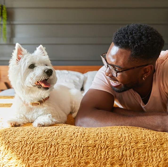 Man smiling at his small dog