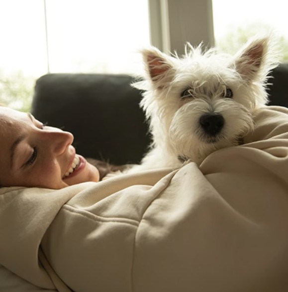 Woman lying down with her adorable small dog