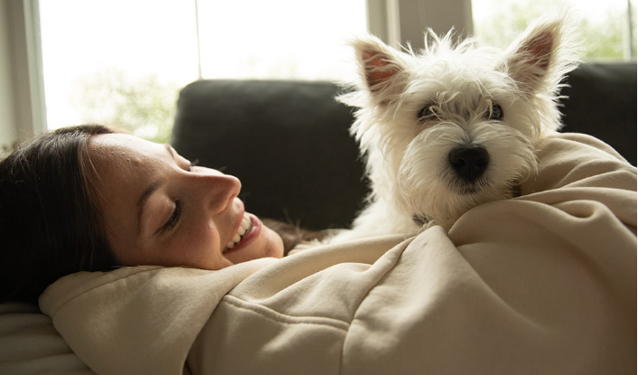 Woman holding her dog and wondering how to take care of a small dog 