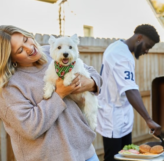 Man and woman cooking dinner while deciding the best dog food for their small dog 